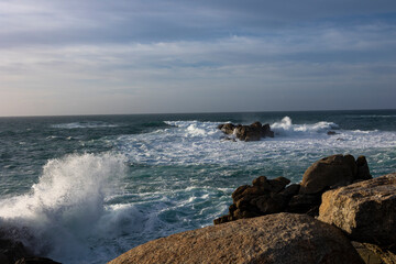 Splashes of the ocean near the shore with stones