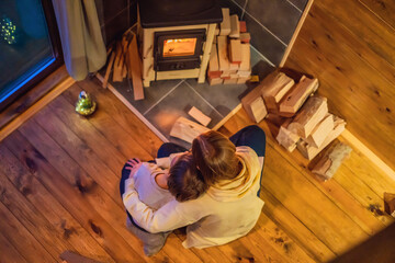 Mom and son spend time by the fireplace in Glamping. Rest in the mountains in Glamping. Cozy fireplace in a mountain house