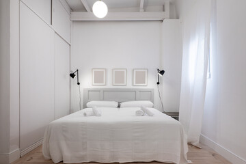 Nice bedroom with king size bed, light pine wood floors, white curtains and white wood and metal beams, built-in wardrobe with sliding doors and gray wood headboard