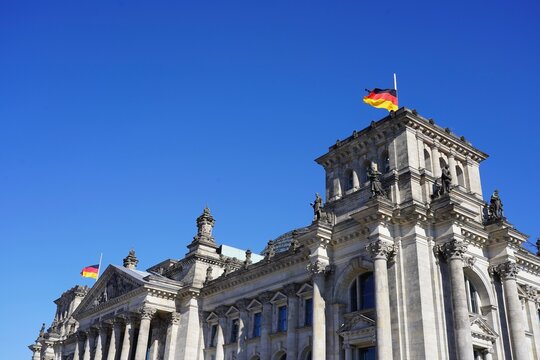 Deutscher Bundestag, das Reichstagsgeb&auml;ude mit Deutschlandfahnen auf halbmast am Gedenktag die Opfer terroristischer Gewalt, Berlin, 11.03.2022