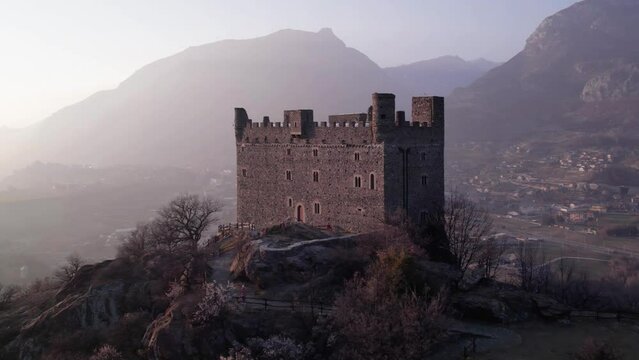Aerial parallax view of Ussel Castle in Aosta Valley in the Alps at sunset.