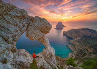 Epic red sunset in Cala Llentrisca with model , Ibiza  - obrazy, fototapety, plakaty