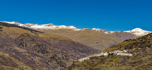 panorama view of the idyllic whitewashed Andalusian mountain village of Capileira in the Sierra Nevada