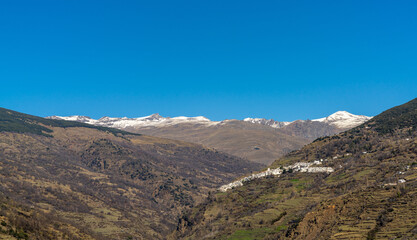 panorama view of the idyllic whitewashed Andalusian mountain village of Capileira in the Sierra Nevada