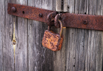 Rusty padlock on old vintage wooden door