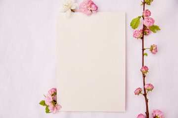 Romantic feminine vertical mockup of stationery card with spring white and pink flowers. Wedding, birthday, invitation, mother's day mock up card concept. Copy space. Top view