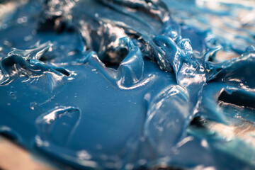 Selective focus of lubricating grease Lithium complex NLGI 3 with blue dye on the plate. Industrial...