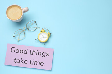 Note with motivational quote Good things take time, alarm clock, cup of coffee and glasses on light...