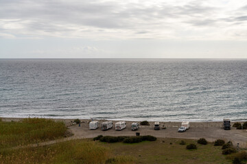 many camper vans and motor homes parked on the beach on the Mediterranean coast of Spain