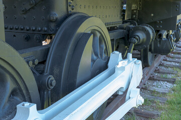 The wheels of an old steam engine on railroad tracks