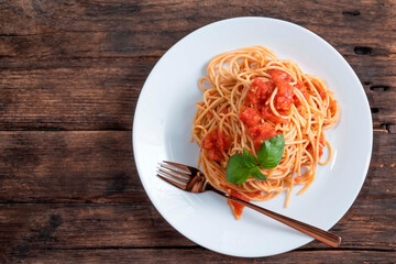 Pasta with tomato sauce in white dish on wood background