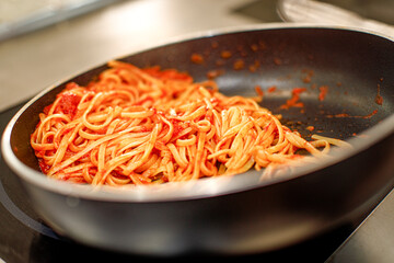 preparazione degli spaghetti  con il sugo in una padella in cucina