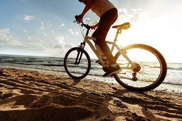 Fototapeta na wymiar image of a man on a bicycle ride on a sandy beach.