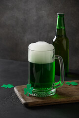 Patrick's day traditional green beer and bottle on black background. Vertical format.
