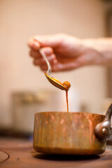 dettaglio di cucchiaio che fa scolare del liquido  da un cucchiaio
