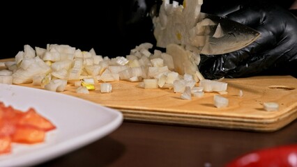 The cook makes salsa. Salsa for burgers on hot Mexican hot recipes. It is prepared from a tomato, red chili peppers, onions, white onions. All chalks are cut with a knife.