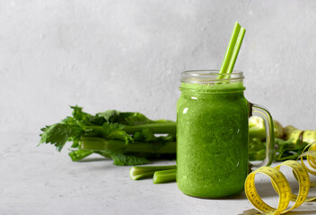 Green smoothie from celery, a healthy diet cold drink in a glass mug on a gray background