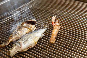 grigliata di pesce in cottura mentre cuoce fumante