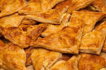 Puffs with cheese and sesame seeds. Ready, baked puff pastries for cheese and sesame seeds.