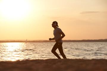 Fototapeta na wymiar young man on an evening jog along the lake shore.