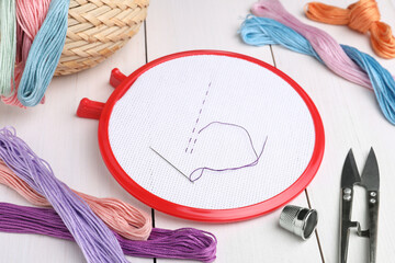 Set of embroidery equipment on white wooden table