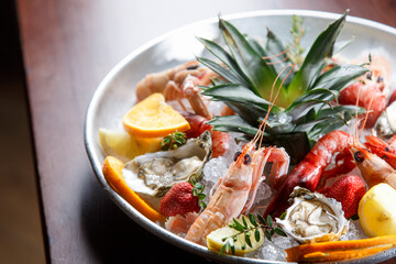  Pesce e frutti di mare crudi serviti su un piatto bianco in un tavolo di legno