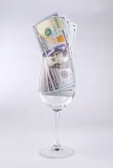 Wine glass with money on white background