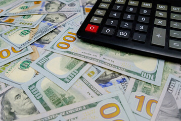 Calculator on the background of money. US dollars banknotes