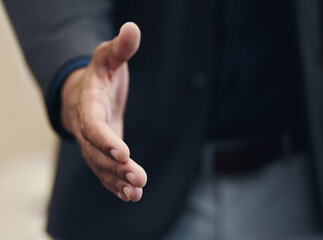 Welcome. Cropped shot of an unrecognizable businessman extending his arm towards the camera for a handshake.