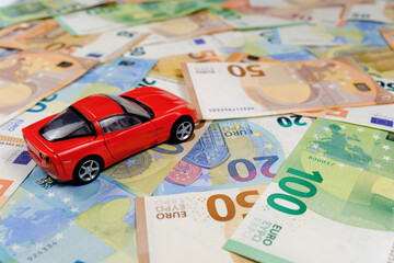Small toy car and money. Loan and finance concepts