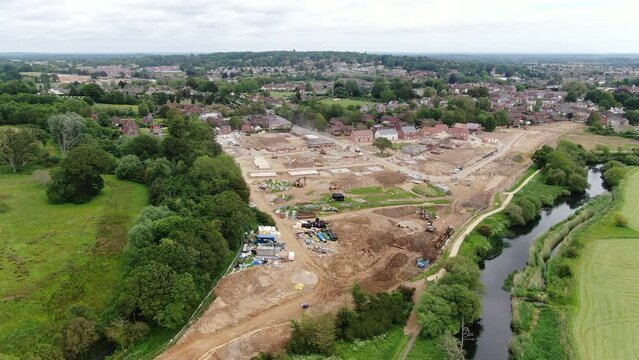 Aerial video with a slow pan over an area of green belt new build development showing housing on the edge of the countryside