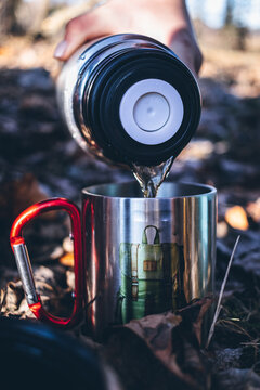 Hot tea or coffee is poured from a thermos. Warming drink for tourist and traveler