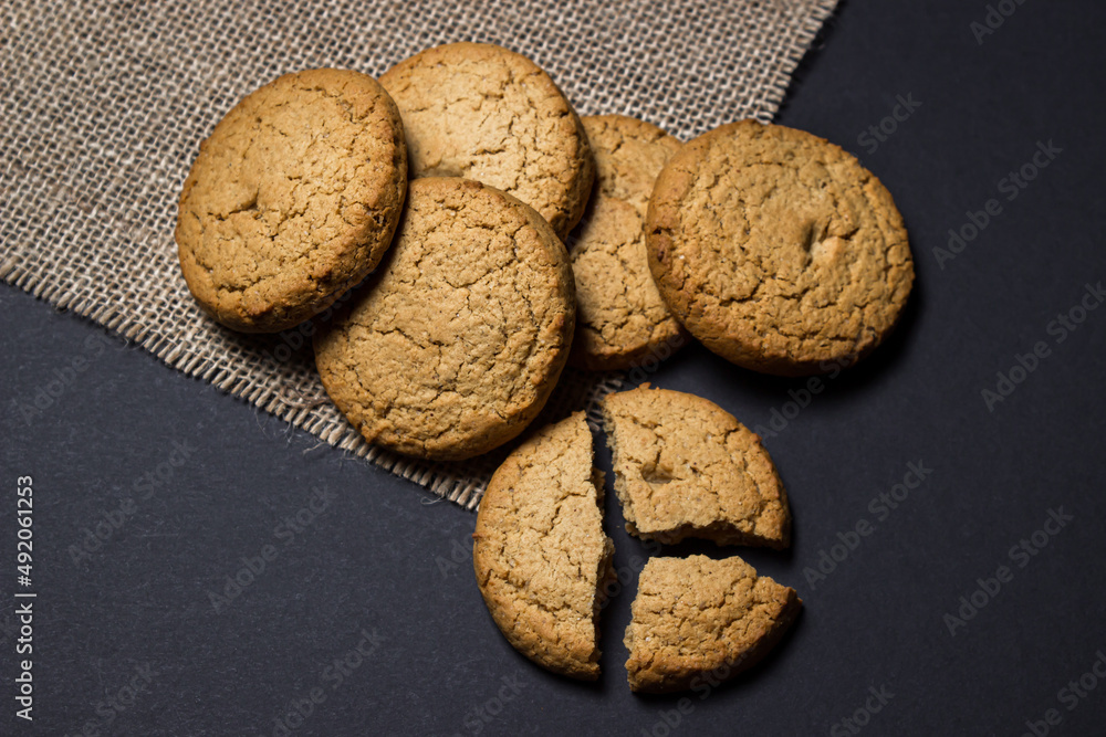 Sticker Oatmeal cookies on a black background. Light and tasty dessert. Healthy breakfast