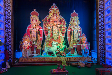 Goddess Durga idol with her family, Durga Puja festival at night. Shot under colored light at...