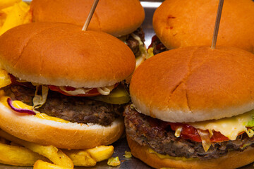 Juicy burgers and fried fries close-up. Ready-made hamburgers with potatoes. Fast food.