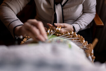Unrecognizable embroiderer making bobbin lace