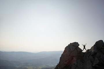 Silhouette of a man on top of a rock in the Carpathian mountains in Ukraine. The concept of freedom