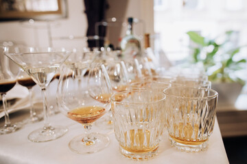 Glasses of whisky, cognac, scotch, martini on table on wedding party