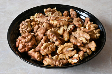 Obraz na płótnie Canvas walnuts in a plate, walnut kernels, peeled walnuts.