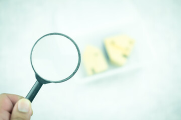Black magnifying glass with a blur of the wood home background. House searching, choice of location for construction