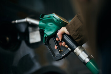 Close-up of woman pouring fuel in gas tank of her car.