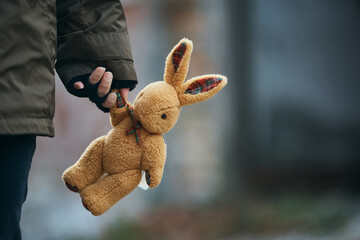 Close-up of person carrying plush bunny while fleeing the war.