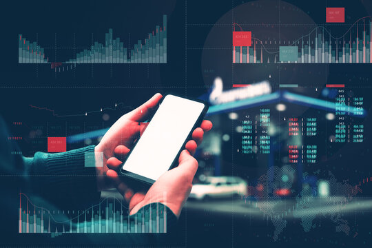 Man holding smartphone mockup with white screen on background gas station with fuel dispensers on technological background. Graph of rising prices for gasoline and fuel.
