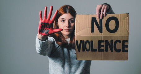 Girl raises the sign that says no violence and the hand with stop war in protest