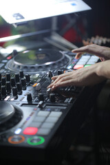 Close up of DJ hands controlling a music table in a night club