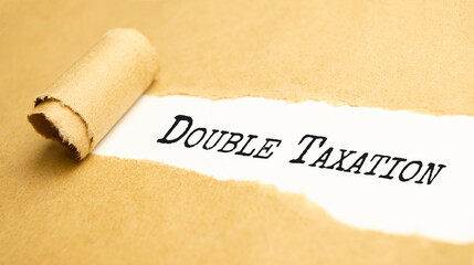 DOUBLE TAXATION. text on white paper on torn paper