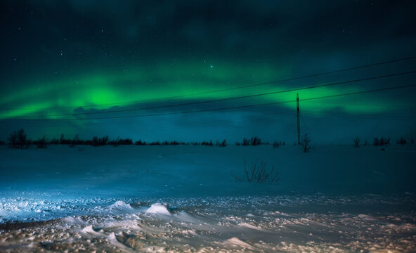 Aurora borealis against the background of power lines on the Kola Peninsula.