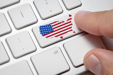Computer keyboard with the US flag map  on it.Male hand on computer white keyboard with american flag map.