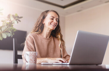 Cheerful woman using silver laptop