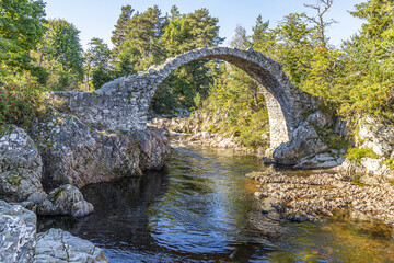 The remains of the Old Packhorse Bridge built in 1717 over the River Dulnain in the village of Carrbridge, Highland, Scotland UK.